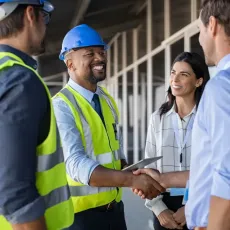 A group of Reston Contractor are shaking hands on a construction site.