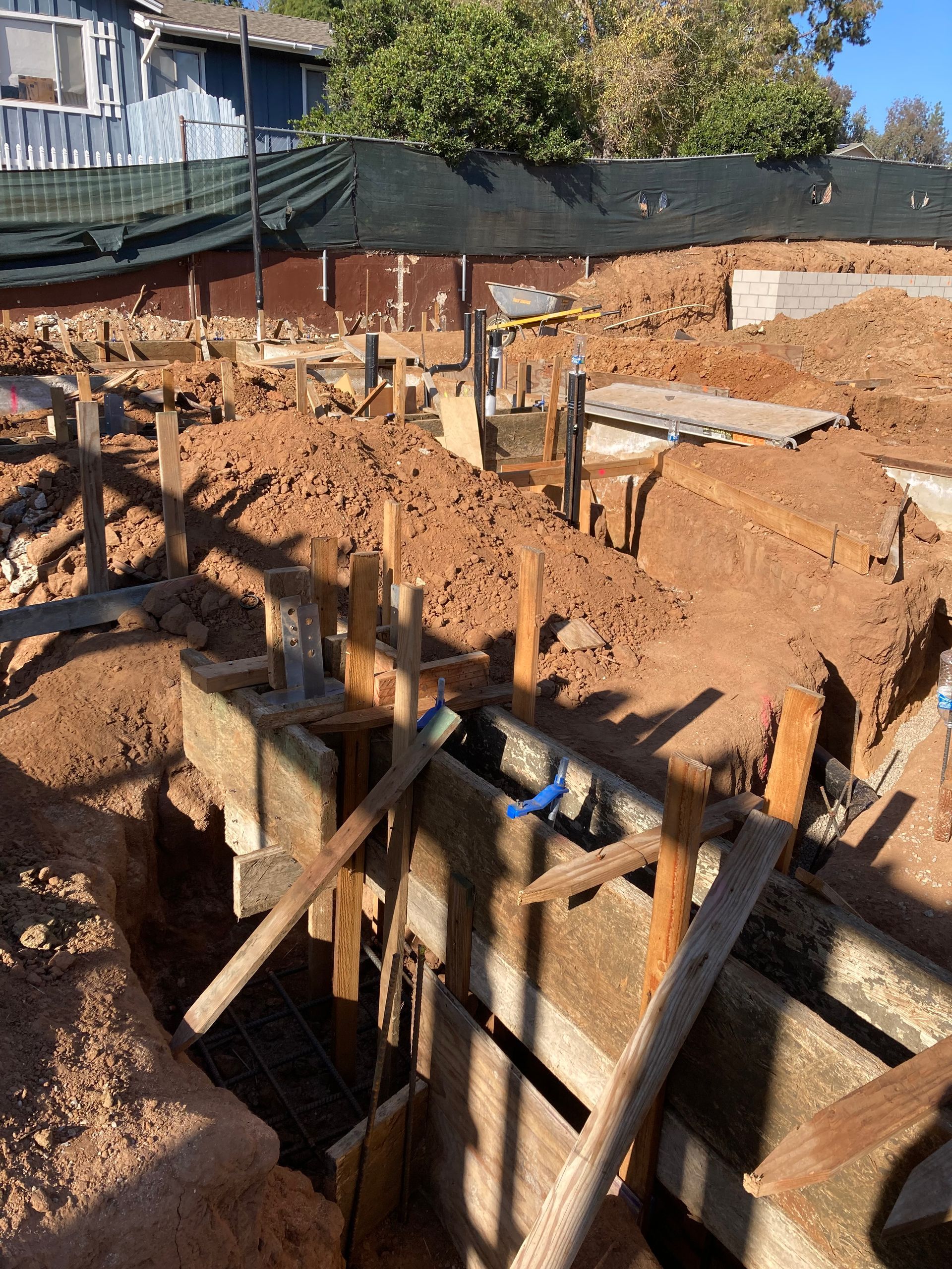 Construction site with wooden formwork, dirt, and concrete structures.