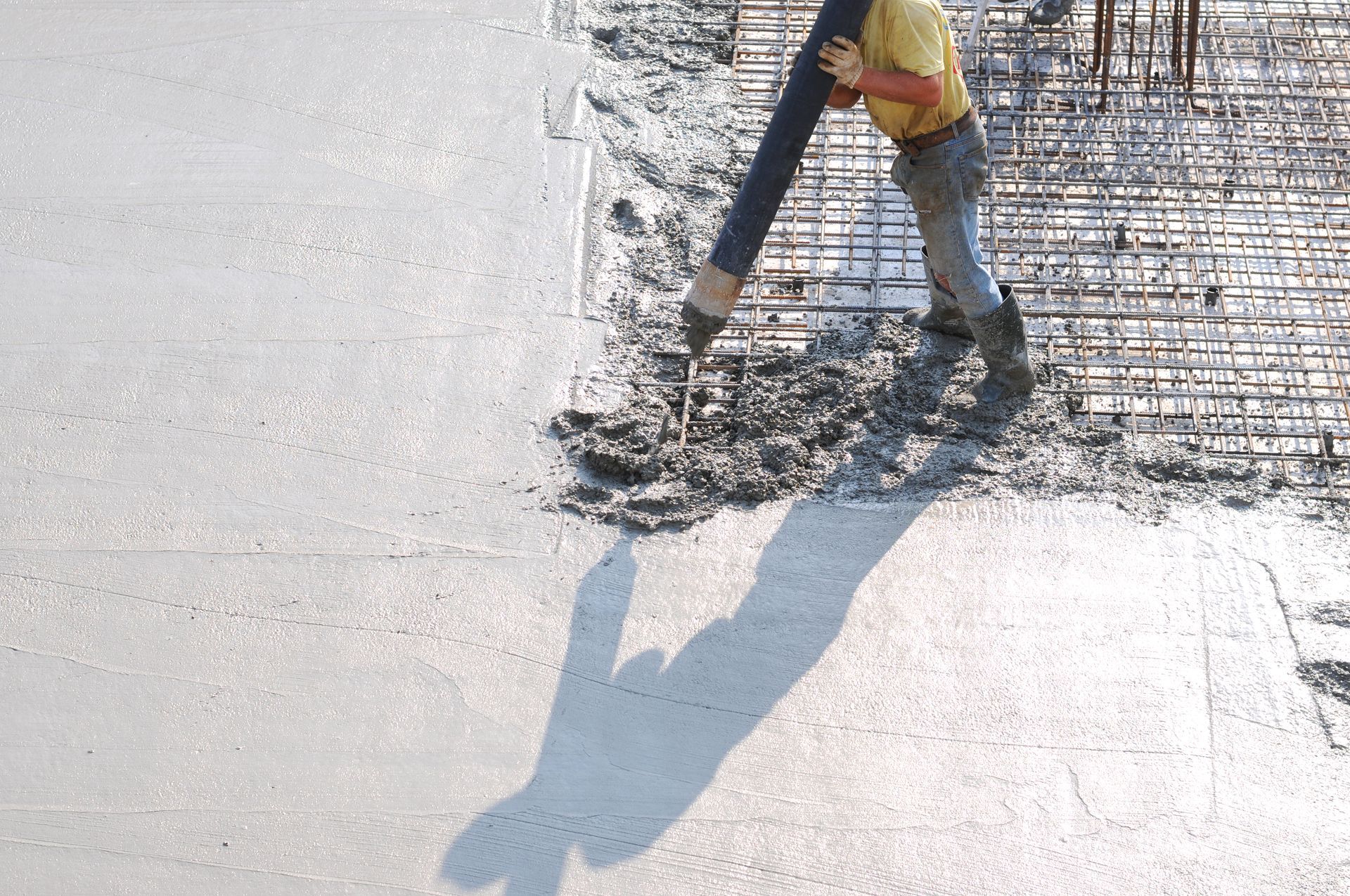 A man is pouring concrete on a concrete floor