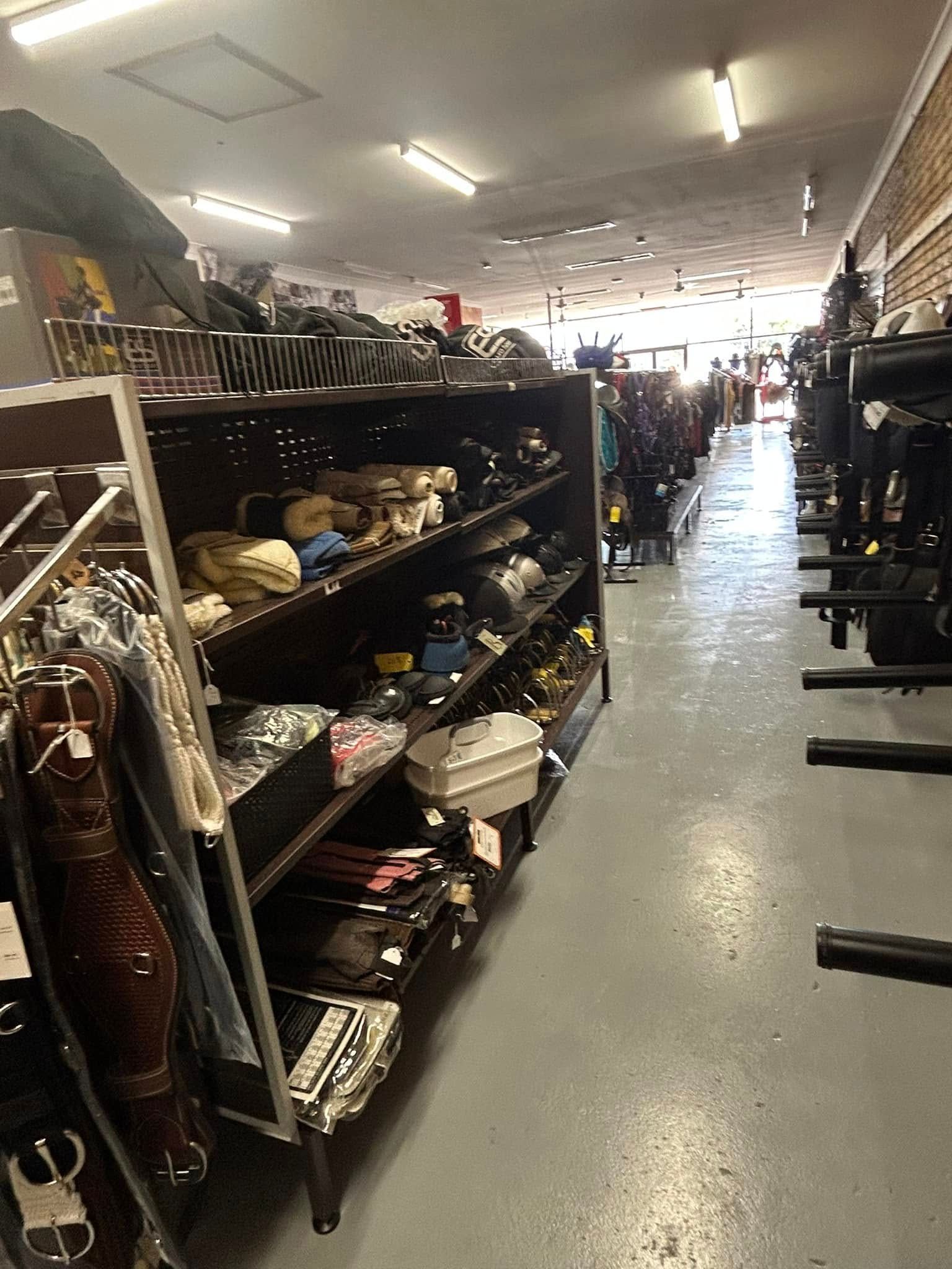 A store filled with lots of shelves filled with clothes and umbrellas. — Paint Horse Saddlery In Taree, NSW