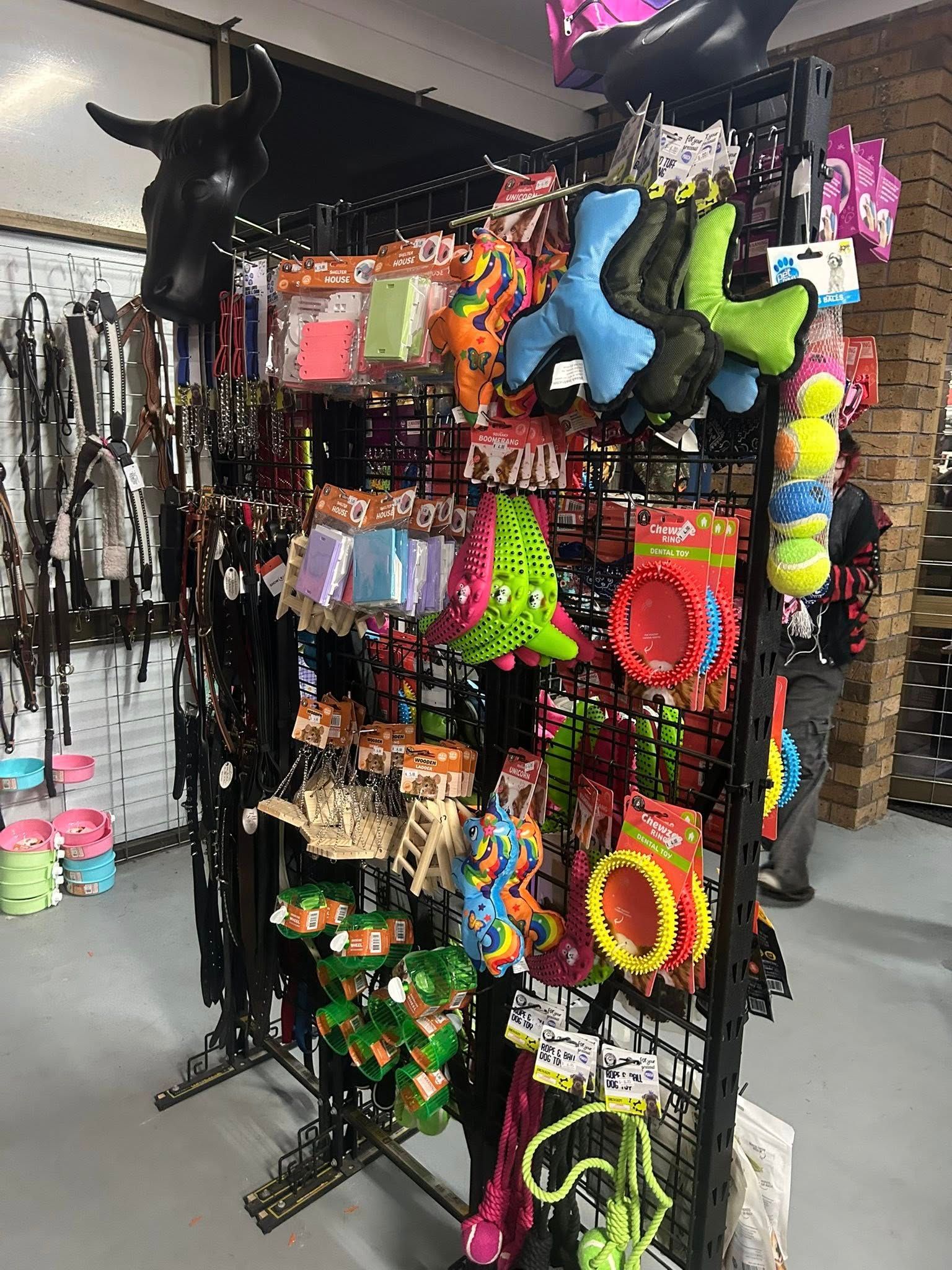 A bunch of pet toys are hanging on a rack in a store. — Paint Horse Saddlery In Taree, NSW