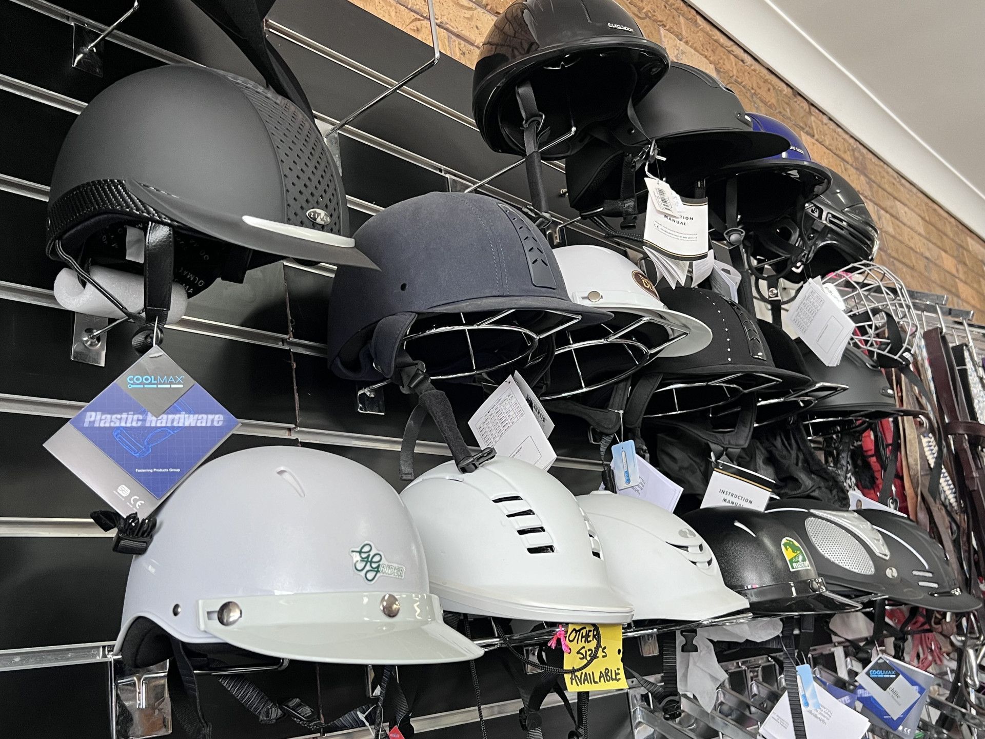 Two helmets are sitting on a wooden shelf in a store. — Paint Horse Saddlery In Taree, NSW