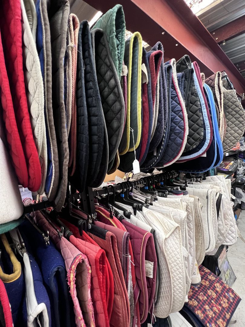 A bunch of saddle pads are sitting in front of a store window. — Paint Horse Saddlery In Taree, NSW
