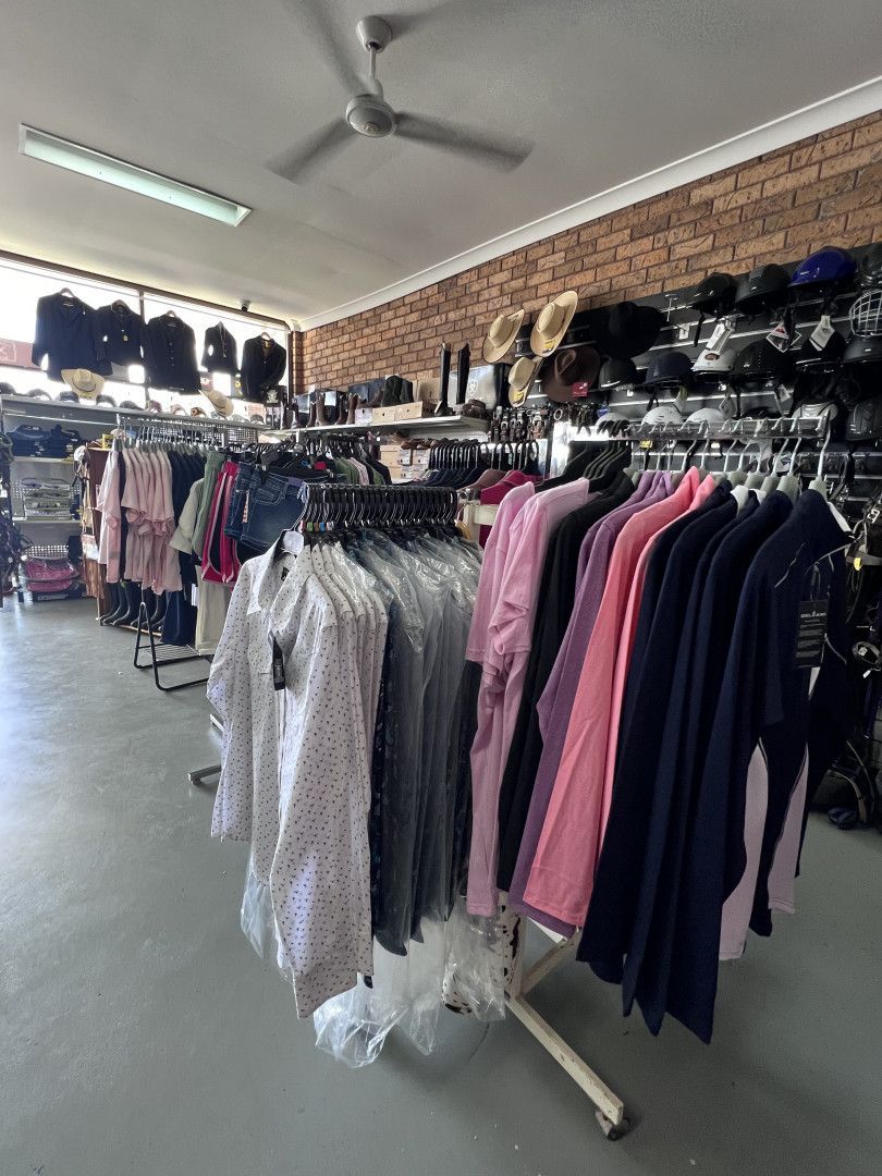 A bunch of clothes are hanging on a rack in a store. — Paint Horse Saddlery In Taree, NSW