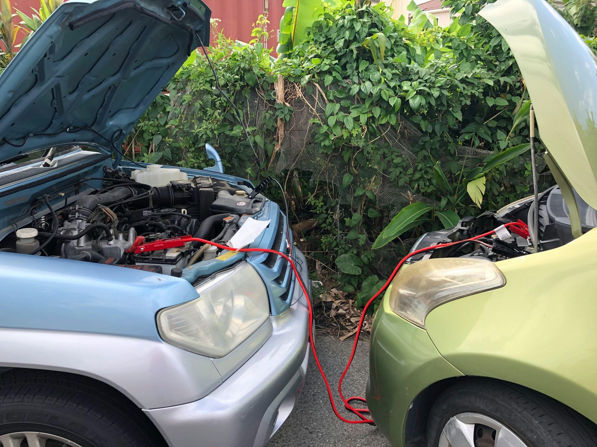 A blue car is being charged by a green car.