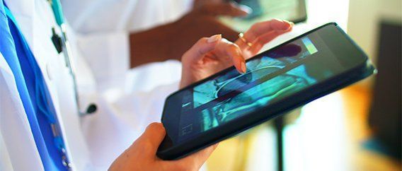 A doctor is using a tablet computer in a hospital.