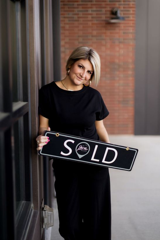 A man in a suit and tie is smiling with his arms crossed