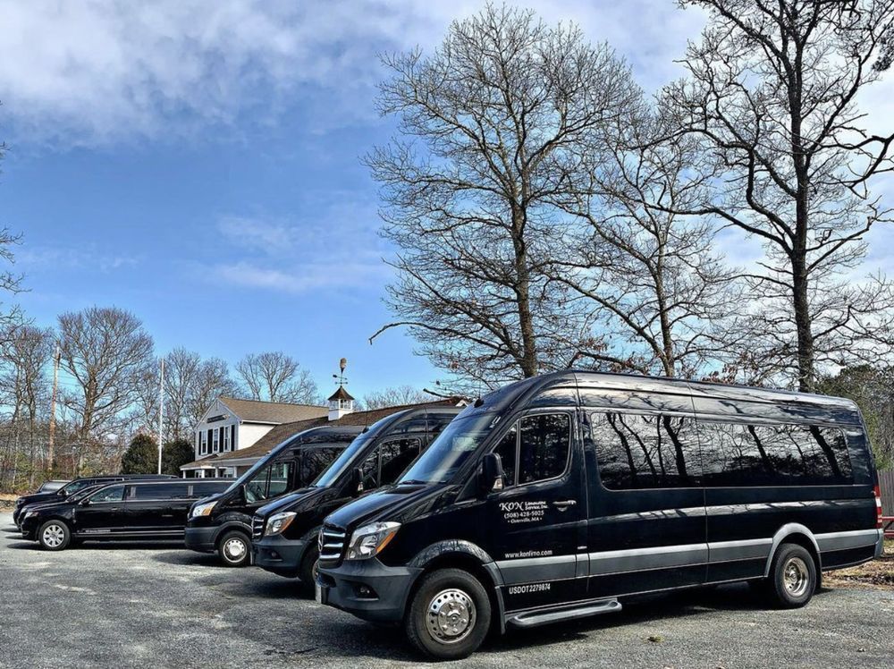 Three black vans are parked next to each other in a parking lot.