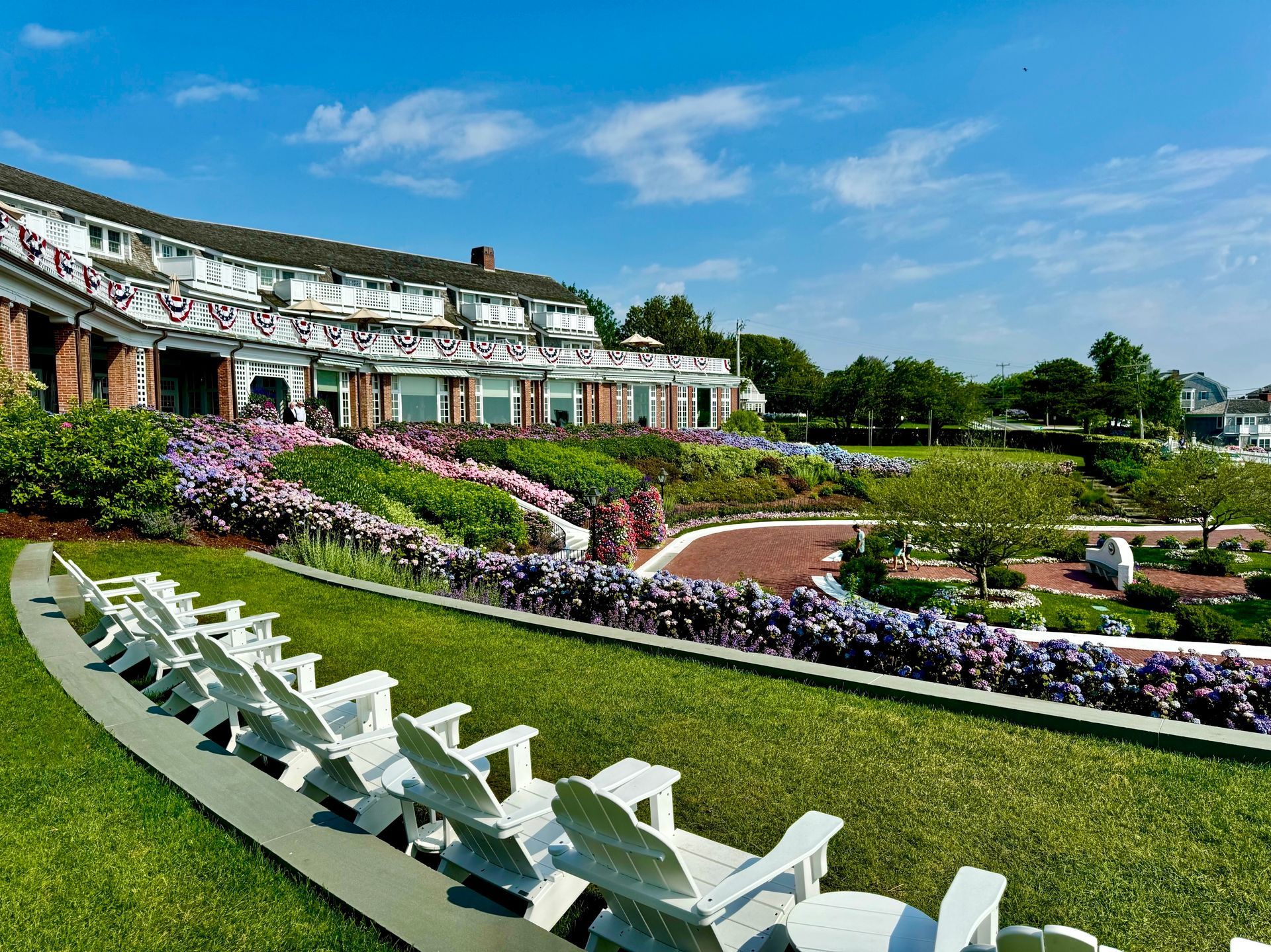 A row of white chairs are lined up in front of a large building.