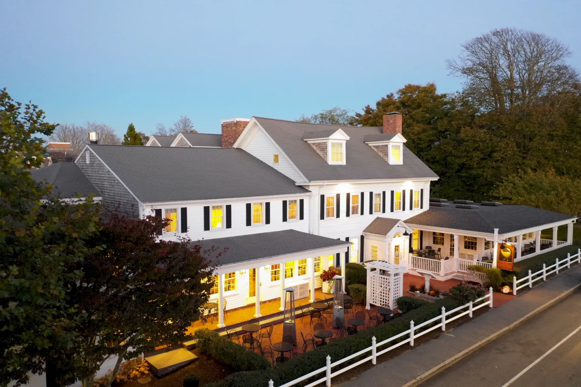 An aerial view of a large white house with a fence around it