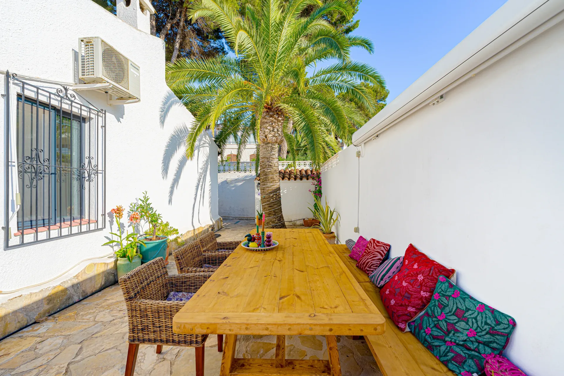 Houten eettafel en zithoek op het terras van Villa Fio in Moraira