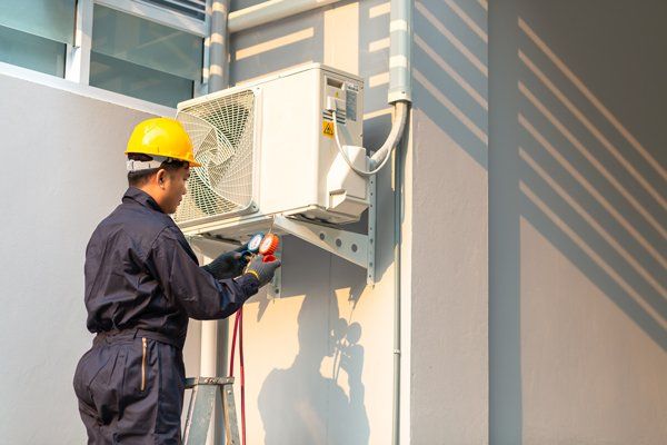 Professional Worker Checking Air Condition Unit — Sterling Heights, MI — McQuade Heating & Cooling Plumbing & Refrigeration