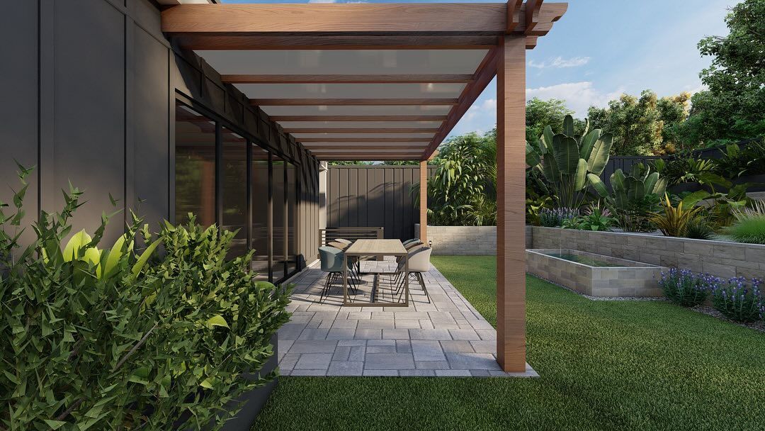 Patio with wooden pergola, dining table, and greenery next to a house.