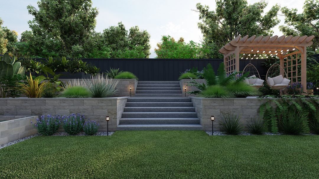 A garden with stone steps, retaining walls, greenery, a pergola, and a dark fence.