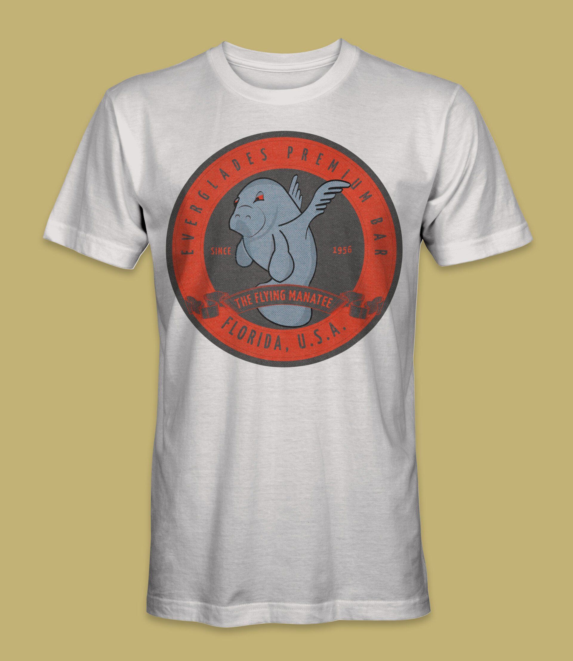 White t-shirt with a circular graphic of a manatee with wings, text 