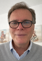 Man wearing glasses smiling, close-up view.