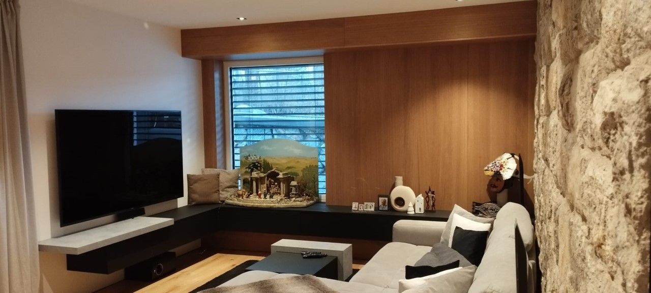 Ein modernes Wohnzimmer mit einem großen, an der Wand montierten Fernseher