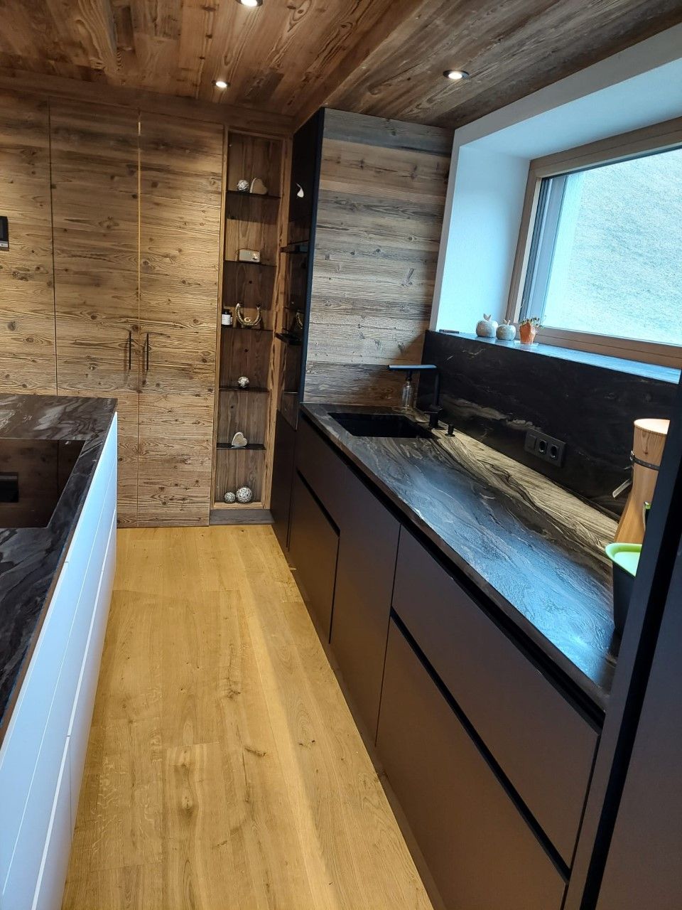 Eine moderne Küche mit Wänden und Decke aus Naturholz