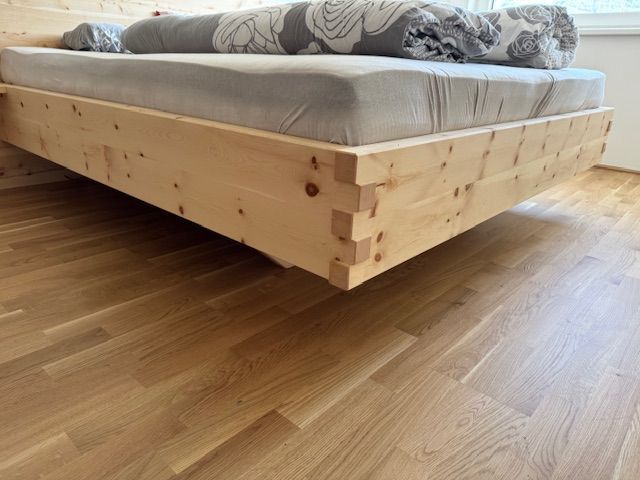 Ein helles Holzplattformbett mit Schwalbenschwanzverbindung an den Ecken