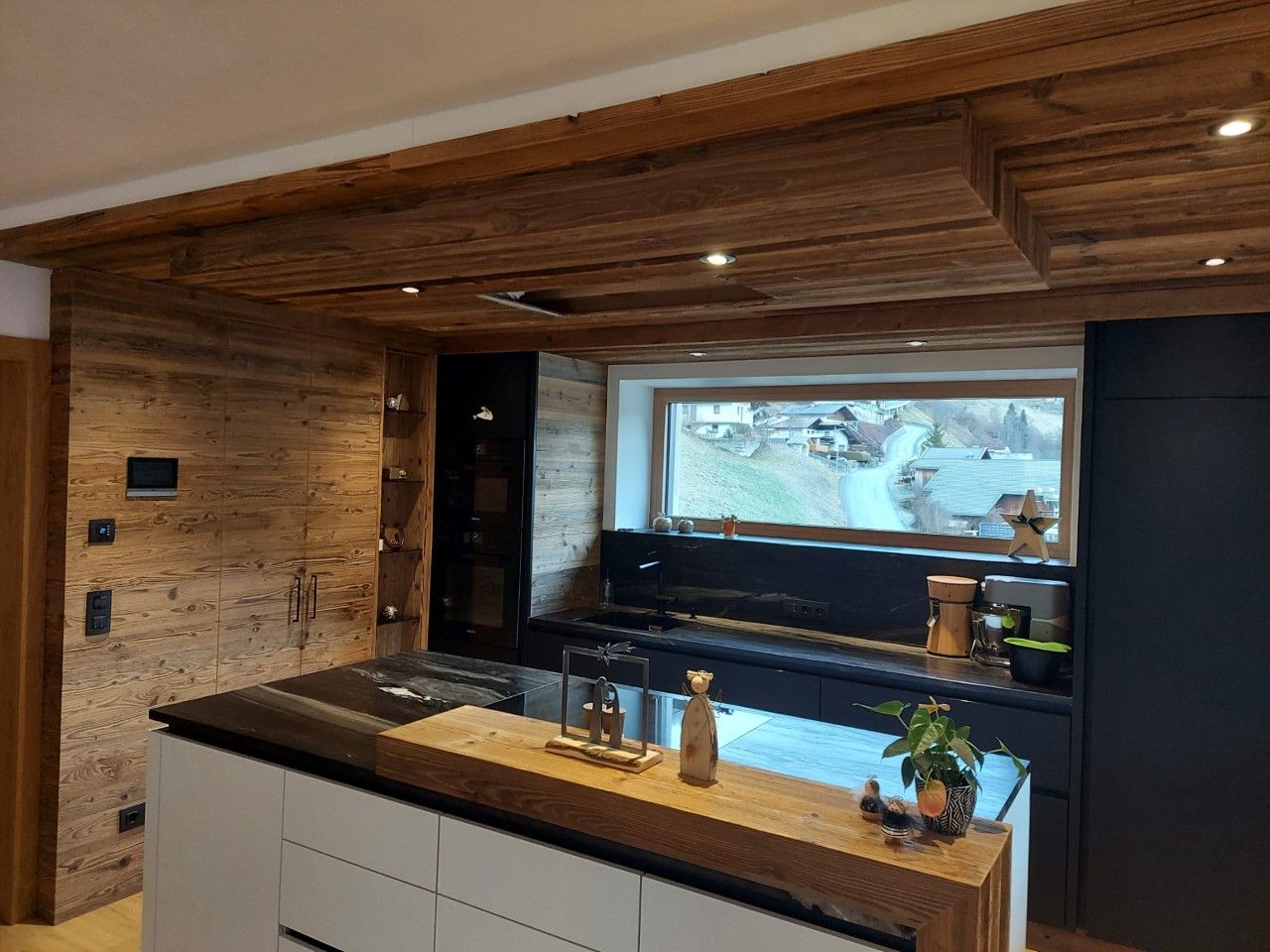 Eine moderne Küche mit rustikaler Holzdecke und -wand