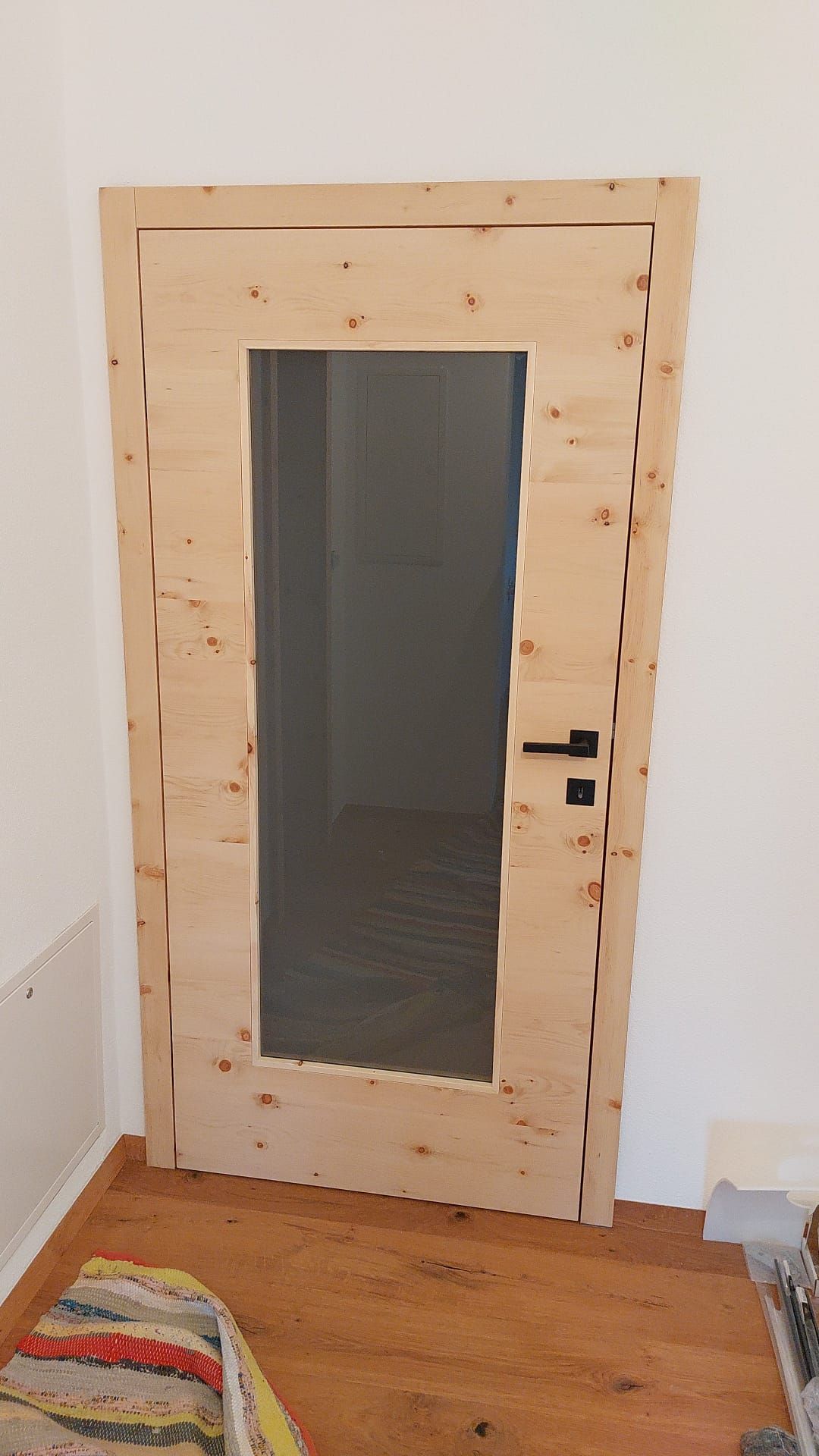 Eine helle Holztür mit einer großen zentralen Glasscheibe