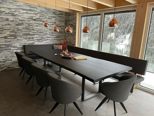 Ein moderner Essbereich mit einem langen dunklen Tisch
