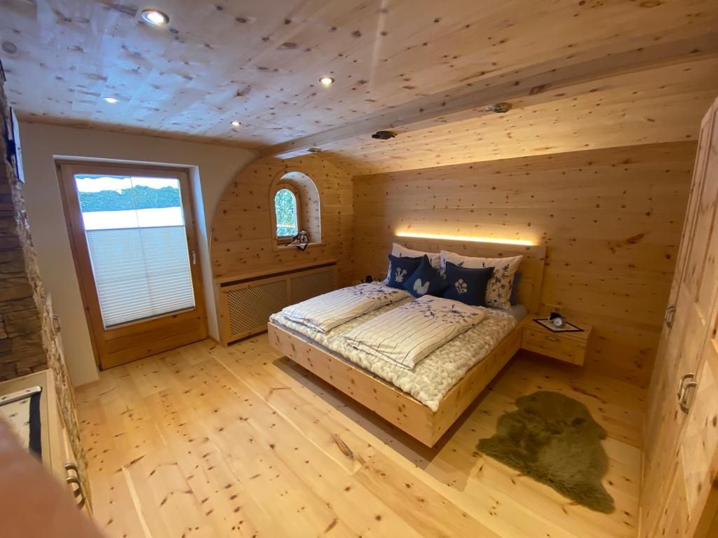 Ein gemütliches, modernes Schlafzimmer mit hellen Holzwänden