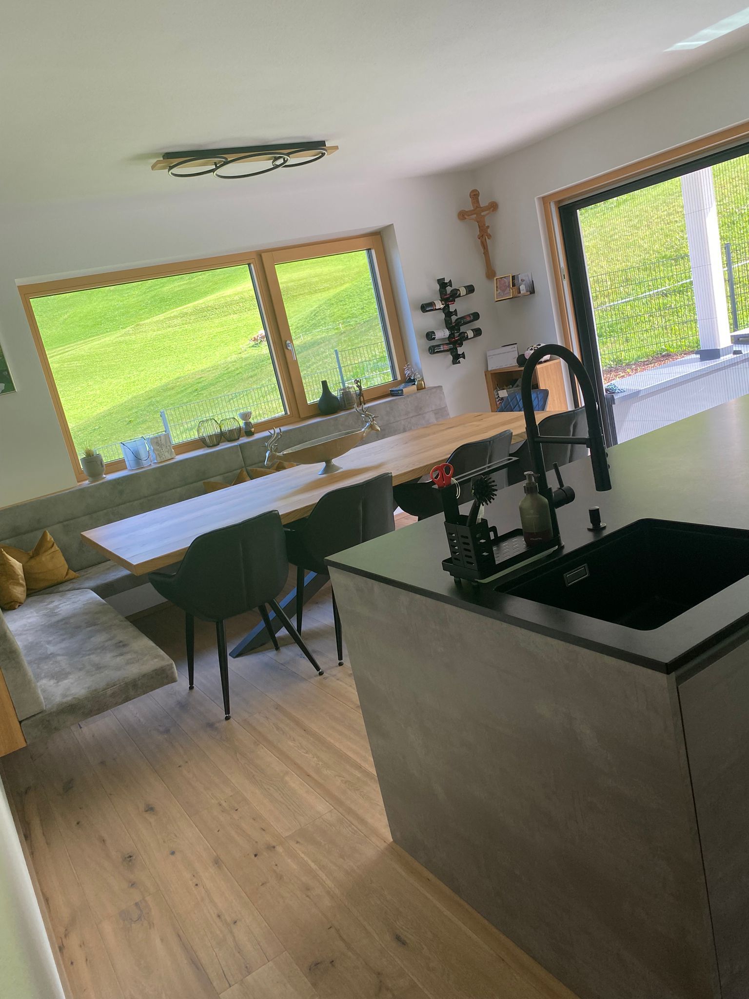 Eine moderne Küche mit einer grauen Kochinsel mit schwarzem Spülbecken