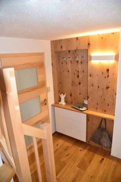 Ein hölzerner Flur mit Garderobenständer, einem weißen Aufbewahrungsschrank