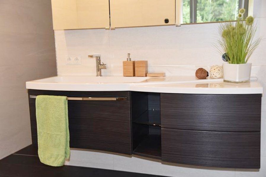 Ein moderner, schwebender Waschtisch mit dunklen Holzschränken