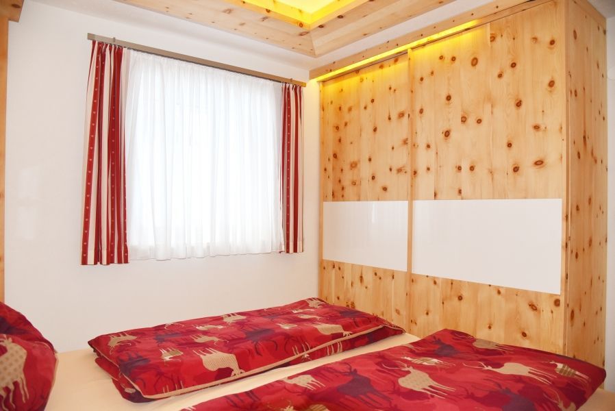 Ein Schlafzimmer mit zwei Betten mit rot gemusterter Bettwäsche