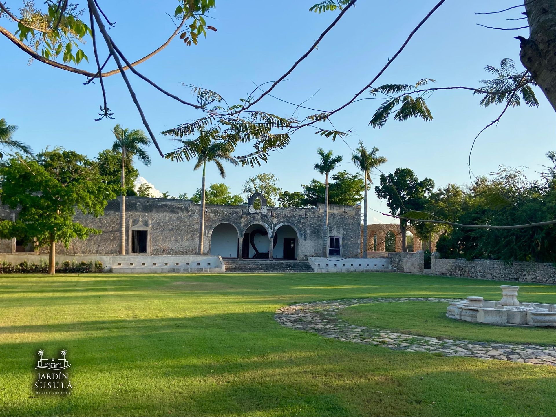 A large lawn with a stone building in the background