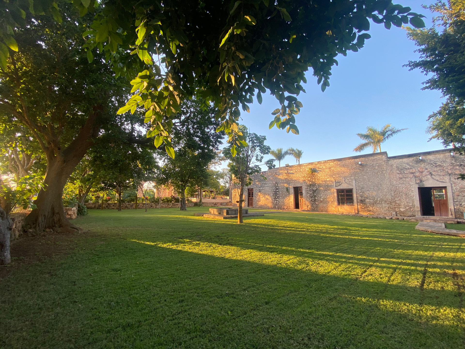 A large grassy area with a stone building in the background