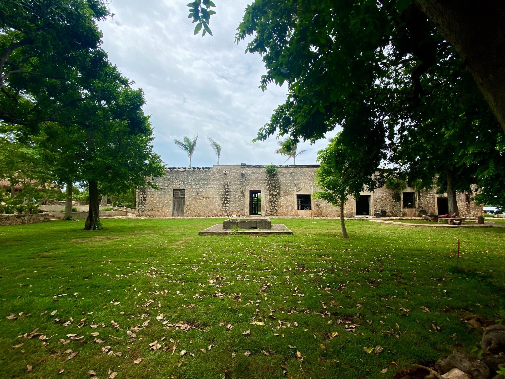 A large stone building is surrounded by trees and grass.