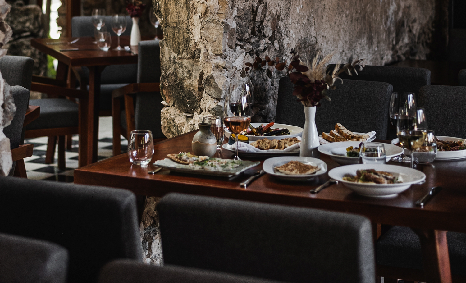 A stone bridge is surrounded by trees and grass in a park.