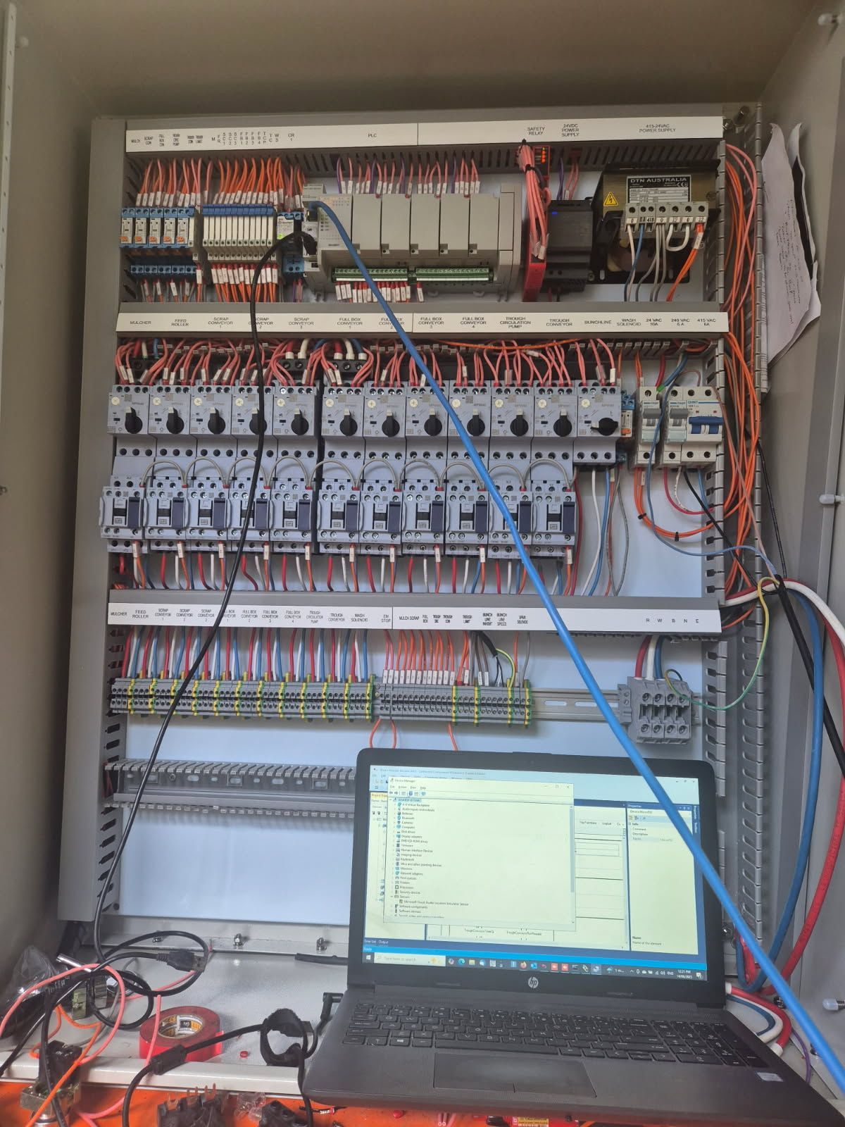 A Man Is Fixing A Light Fixture On The Ceiling — In Electrics In Innisfail, QLD