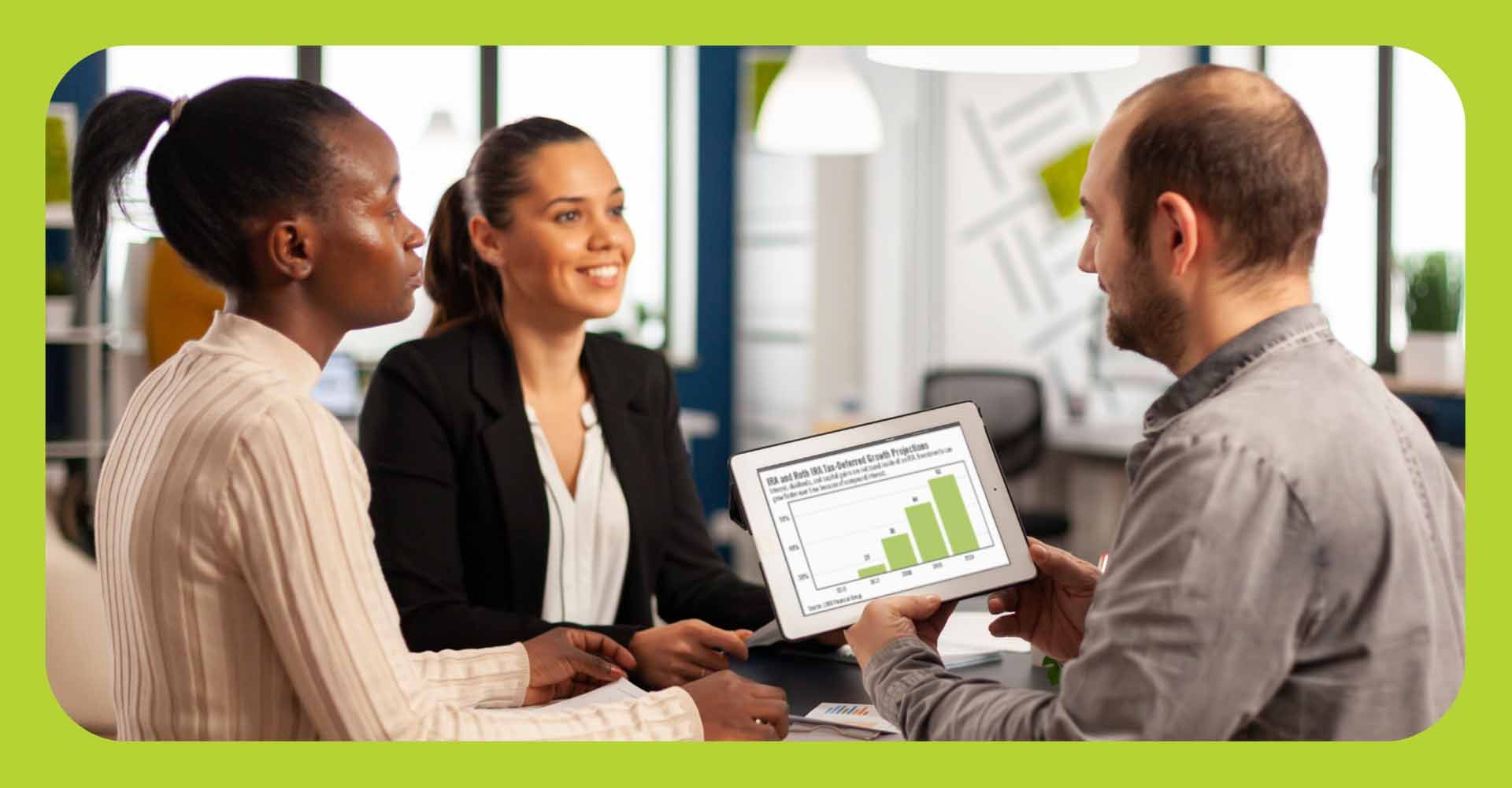 An employer talking to employees looking at a chart on a tablet, in a business setting.