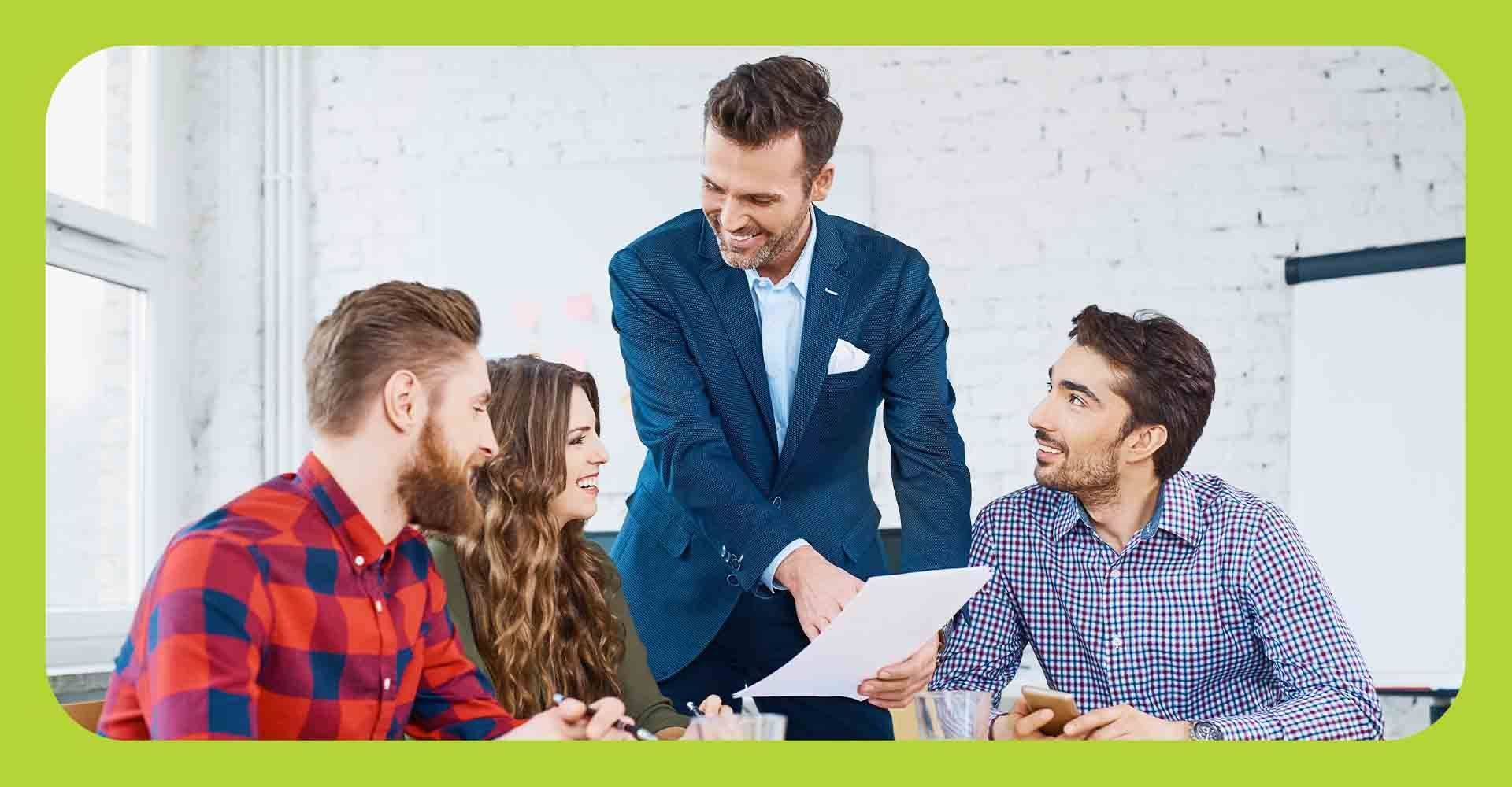 A group of business professionals reviewing paperwork at a conference table.