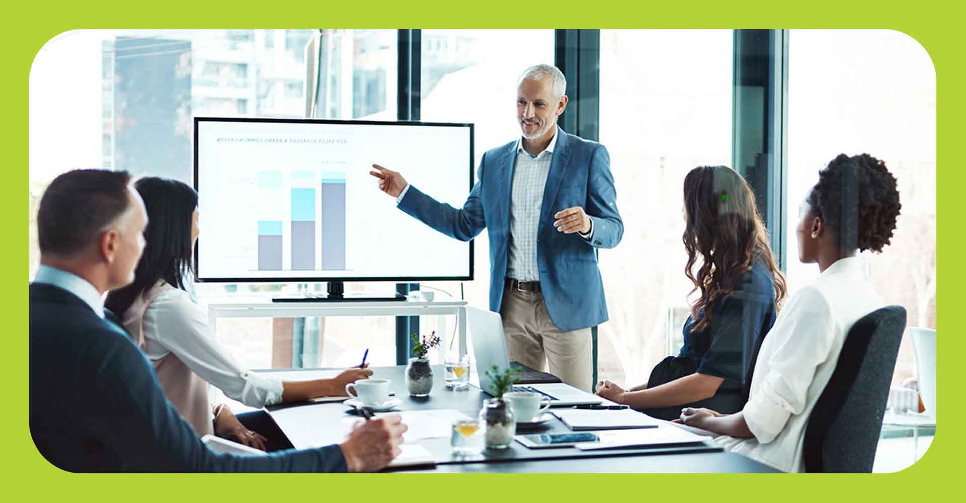 A small business owner presenting to his team in front of a digital screen
