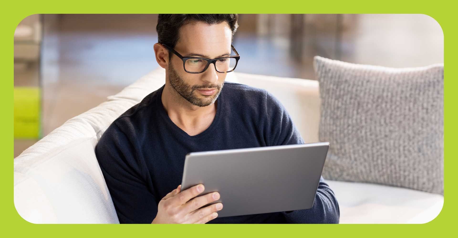 Man wearing glasses looking at a tablet