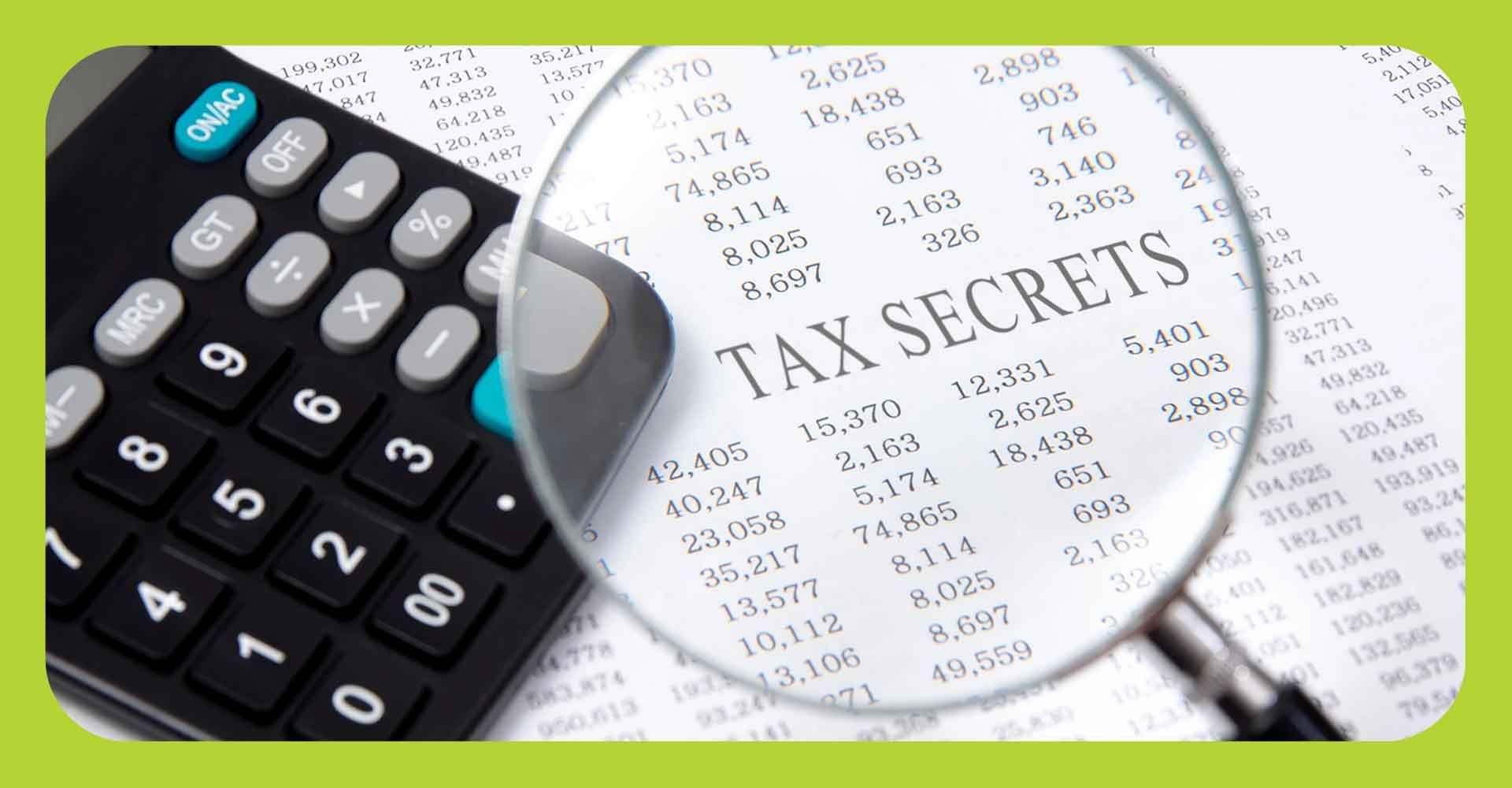 Tax paperwork, calculator and a magnifying glass