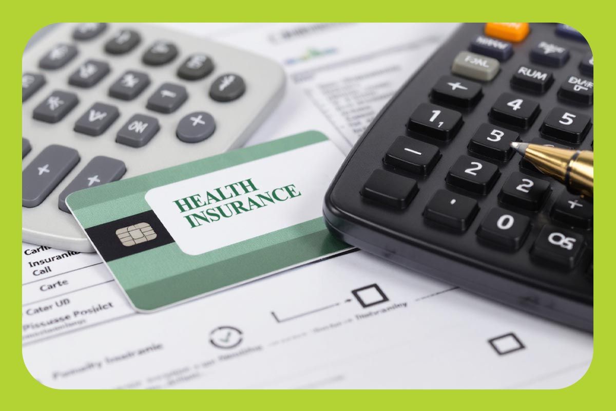 A health insurance membership card next to calculators and paperwork