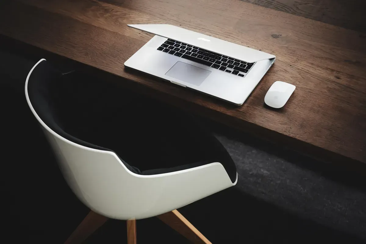 A desk with a laptop and a mouse on it