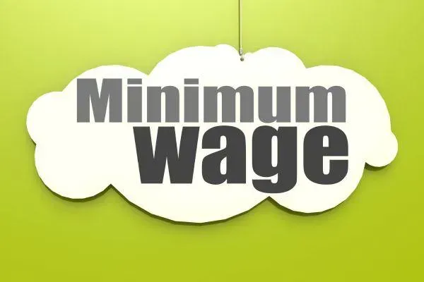 A sign that says minimum wage on a green background
