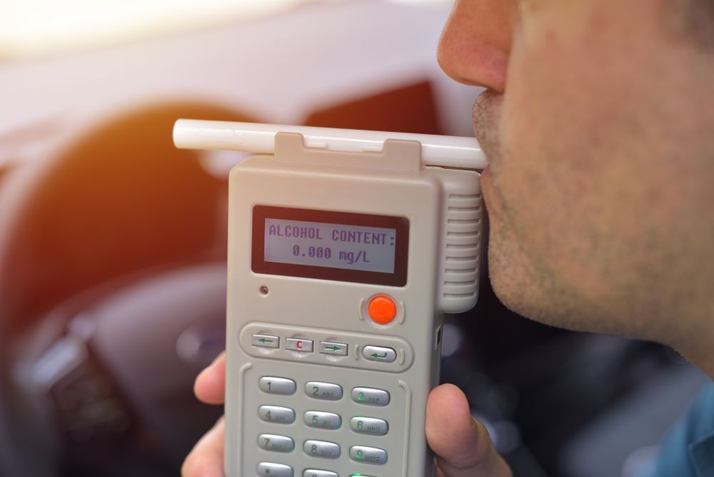 Person Blowing Into a Breathalyser in a Car — DAB Services in Cannonvale, QLD