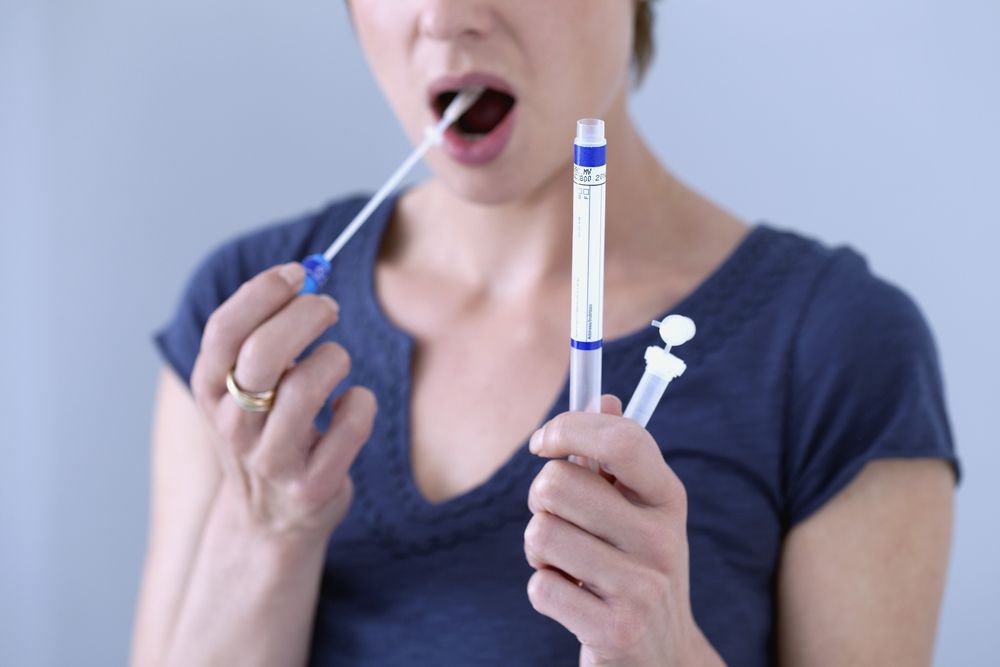 Woman Taking a Saliva Test With a Swab — DAB Services in Cannonvale, QLD
