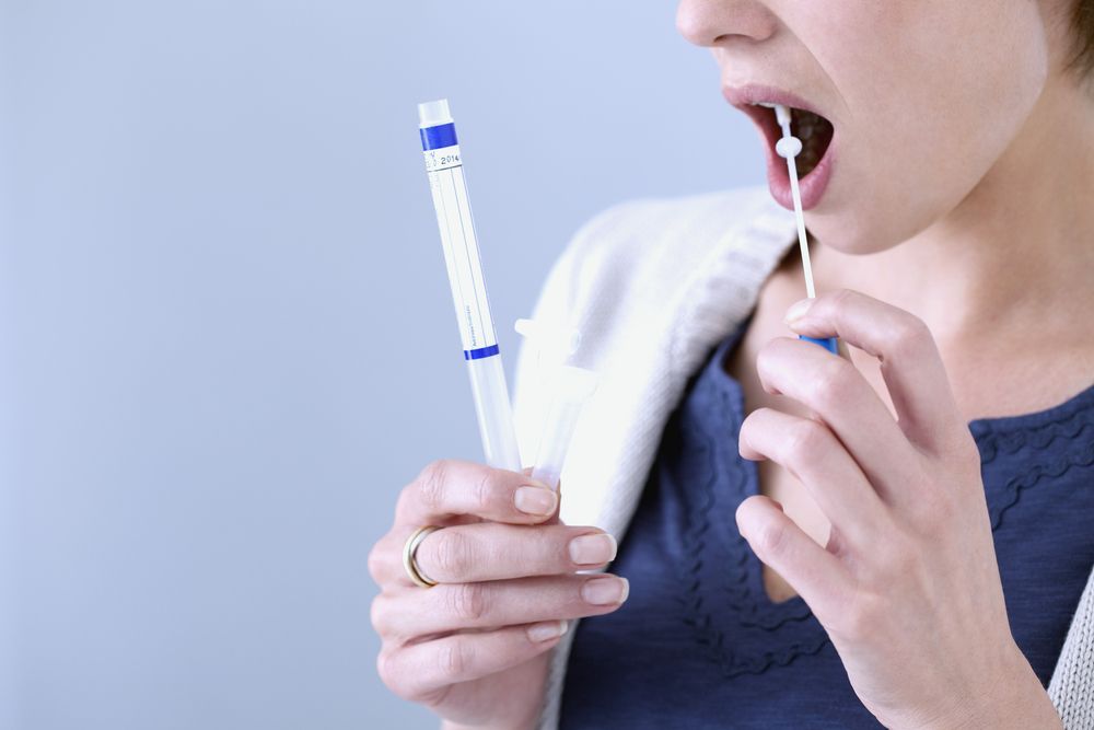 Woman Taking a Mouth Swab Test With a Long Swab — DAB Services in Cannonvale, QLD