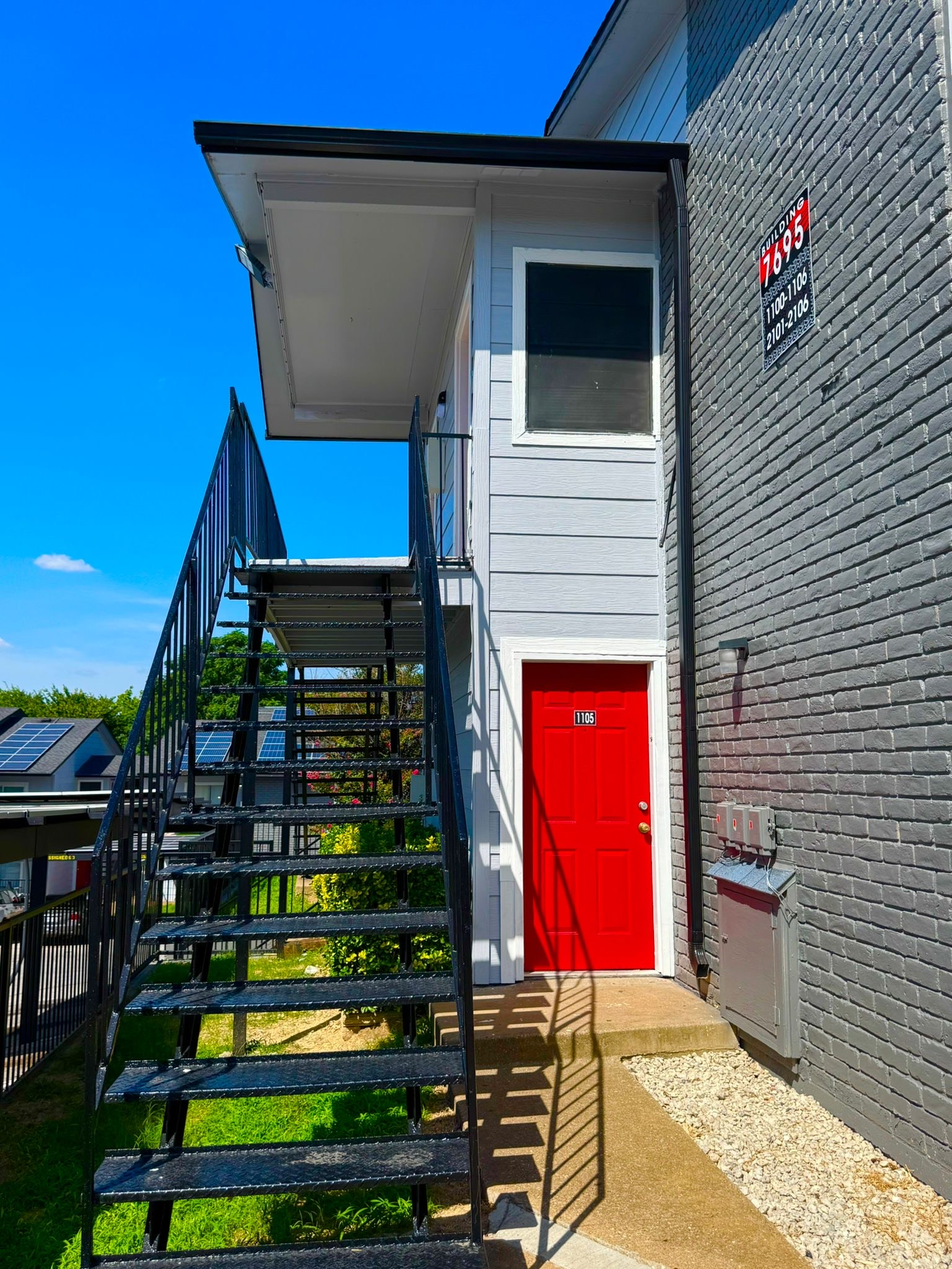 A building with stairs leading up to a red door.