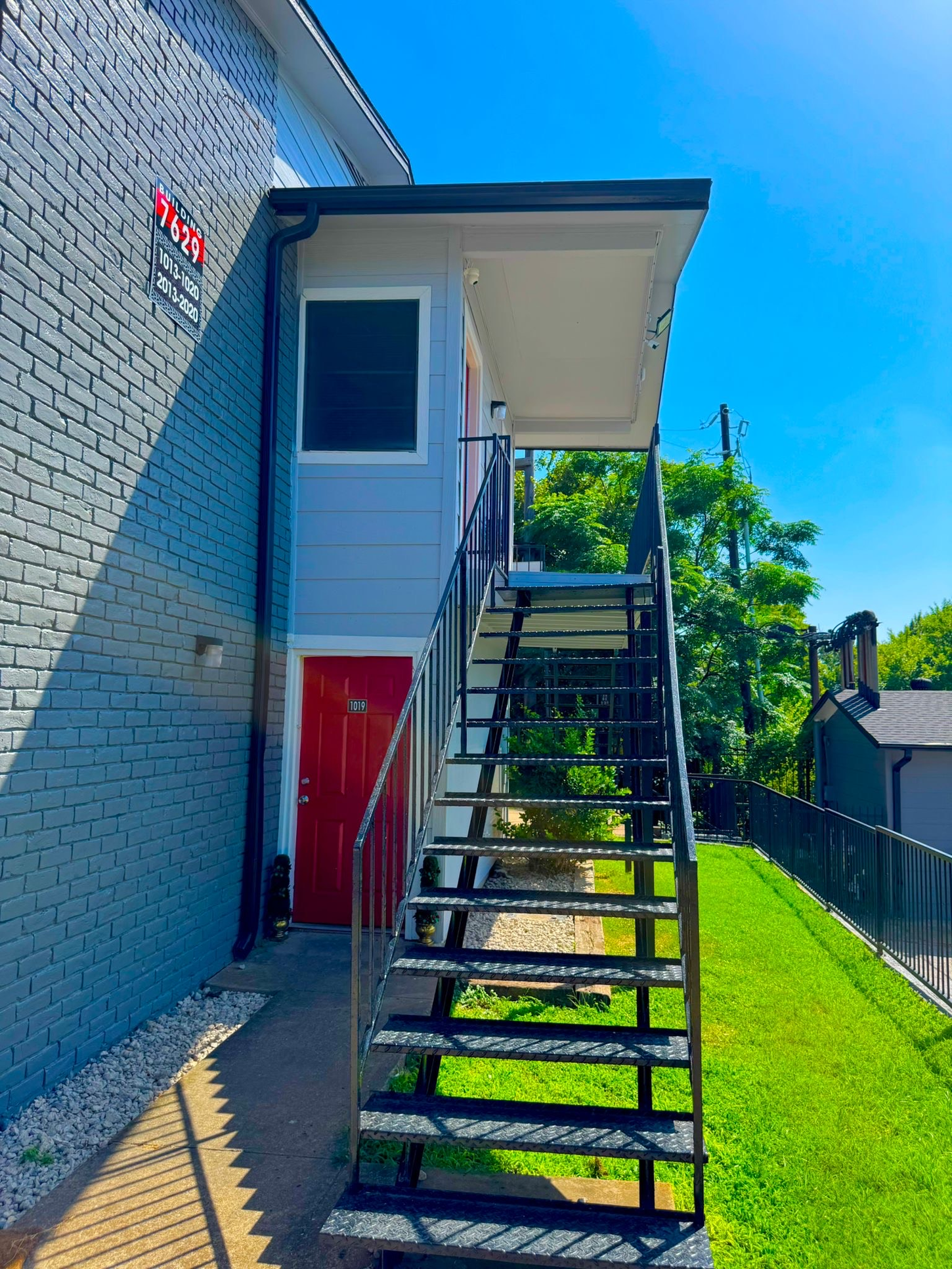 A building with stairs leading up to it and a red door.