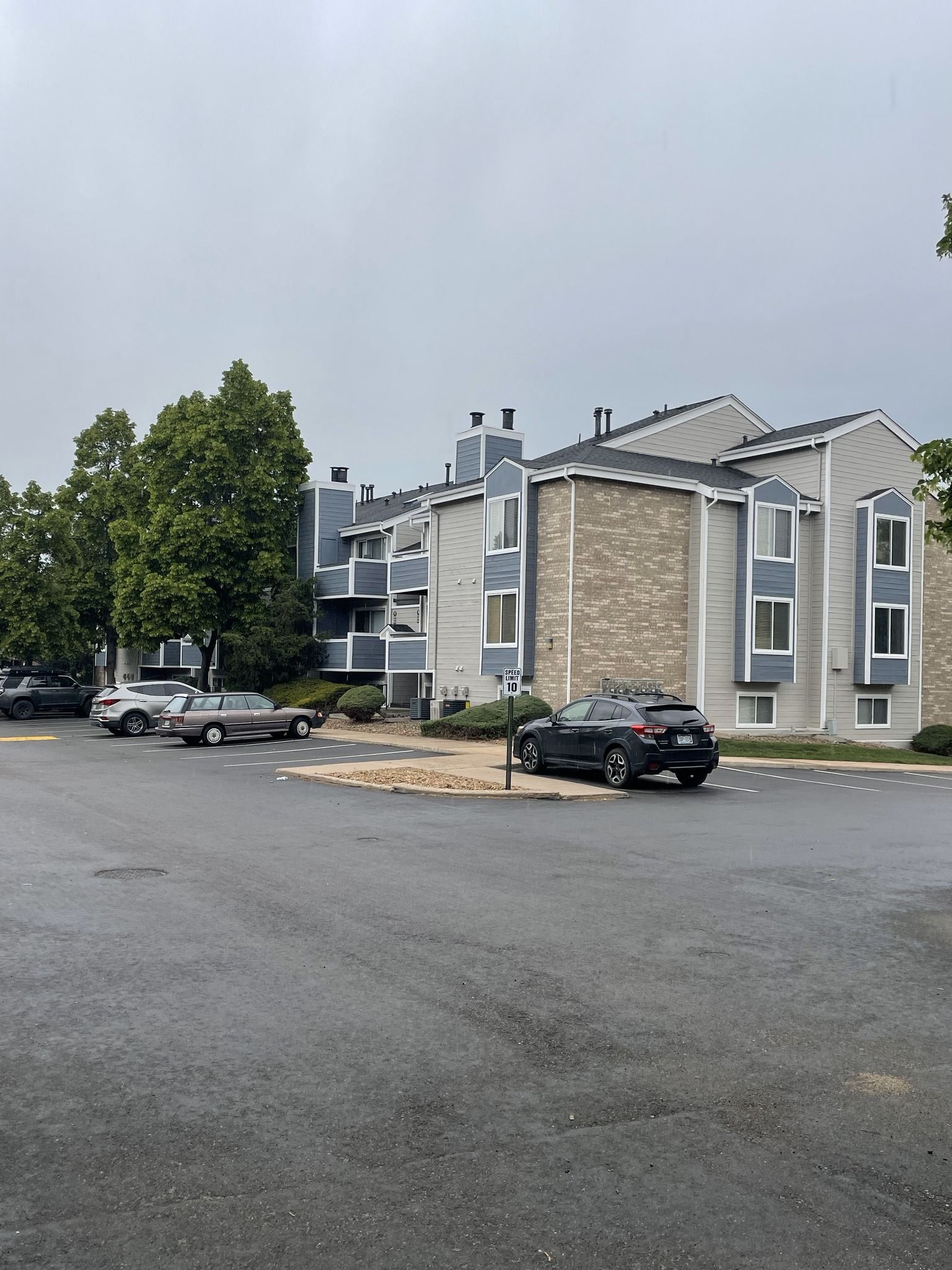 A parking lot with cars parked in front of a building.